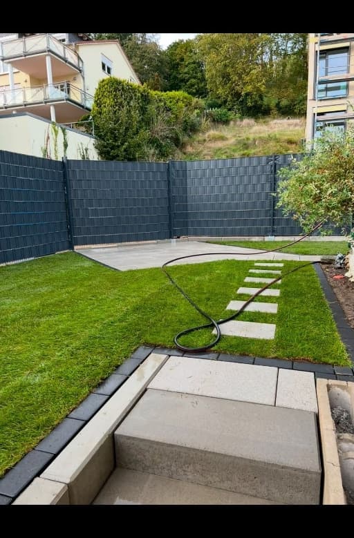 Neuer Gartenzaun mit gepflasterter Terrasse